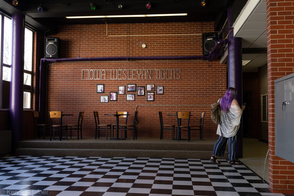 Kendra Hefner, M.A., carrying a backpack and walking out of the Tiger Den. Spring 2023.