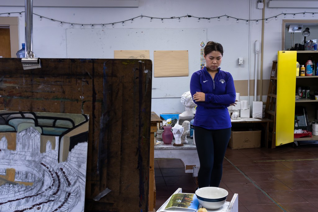Jingyuan (Flora) Hua, IW Digital Media Design student from China, standing alone in the campus art studio. Spring 2023.