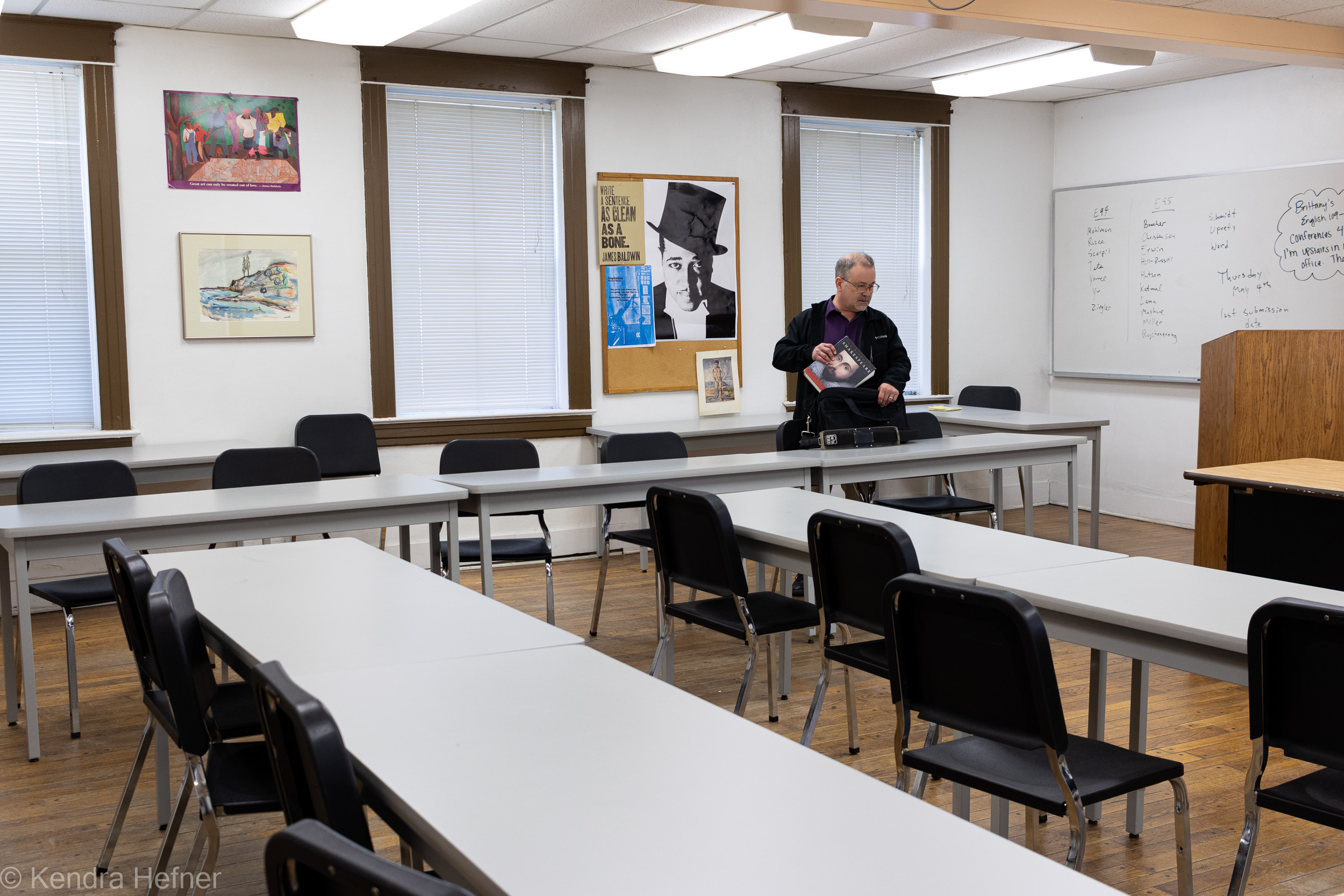 Dr. Jeff Martinek, Professor of English, packing his Shakespeare text book in his empty classroom. Spring 2023.